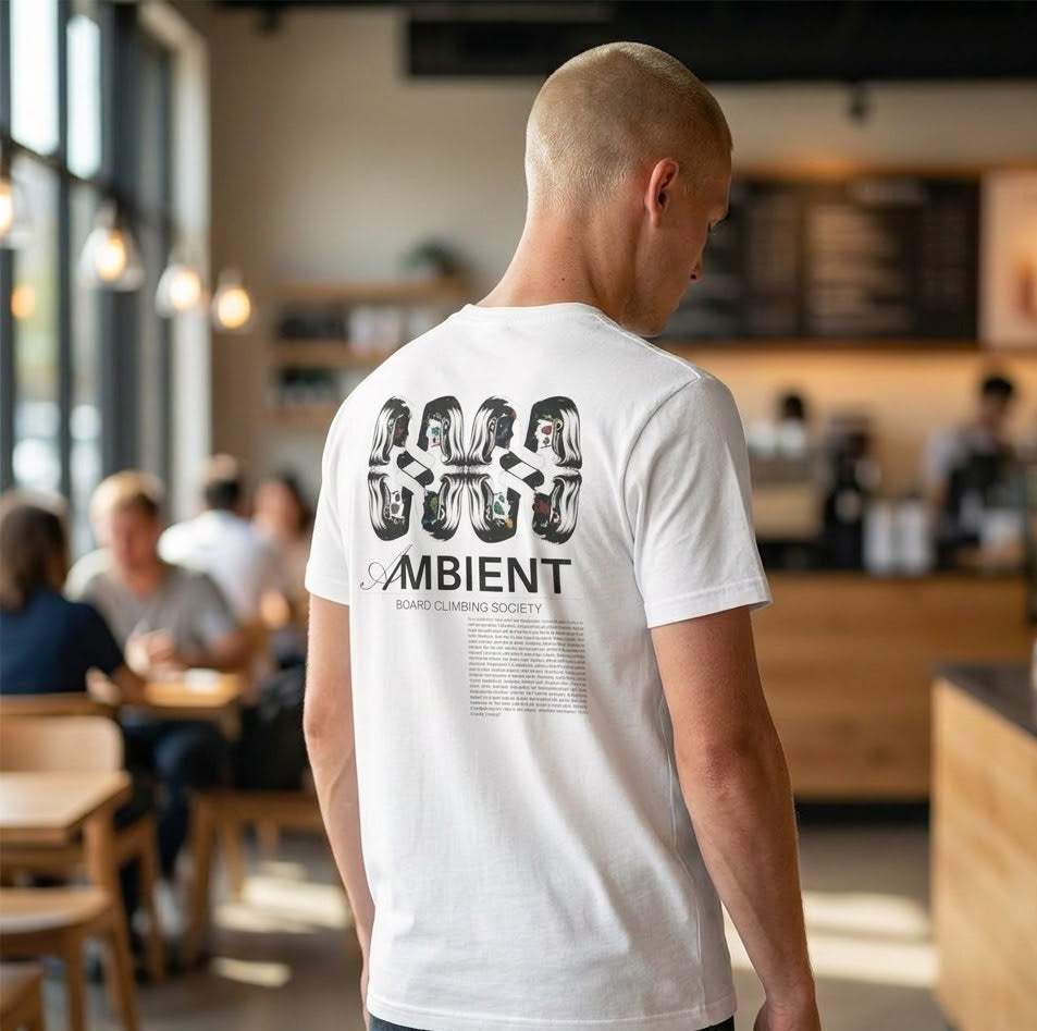 Man wearing a white t-shirt with 'Ambient' design in a cafe setting